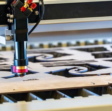 laser cutting machine, cutting wood sheets, while a man takes care of the process, mexico latin america